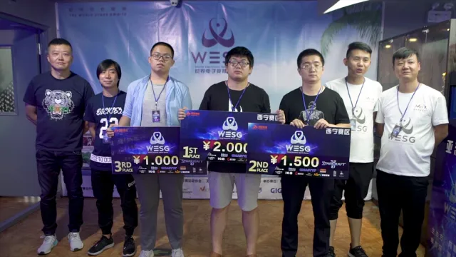 WESG 西宁赛区星际争霸 II 颁奖合影，冠军手持 1ST PLACE 奖牌